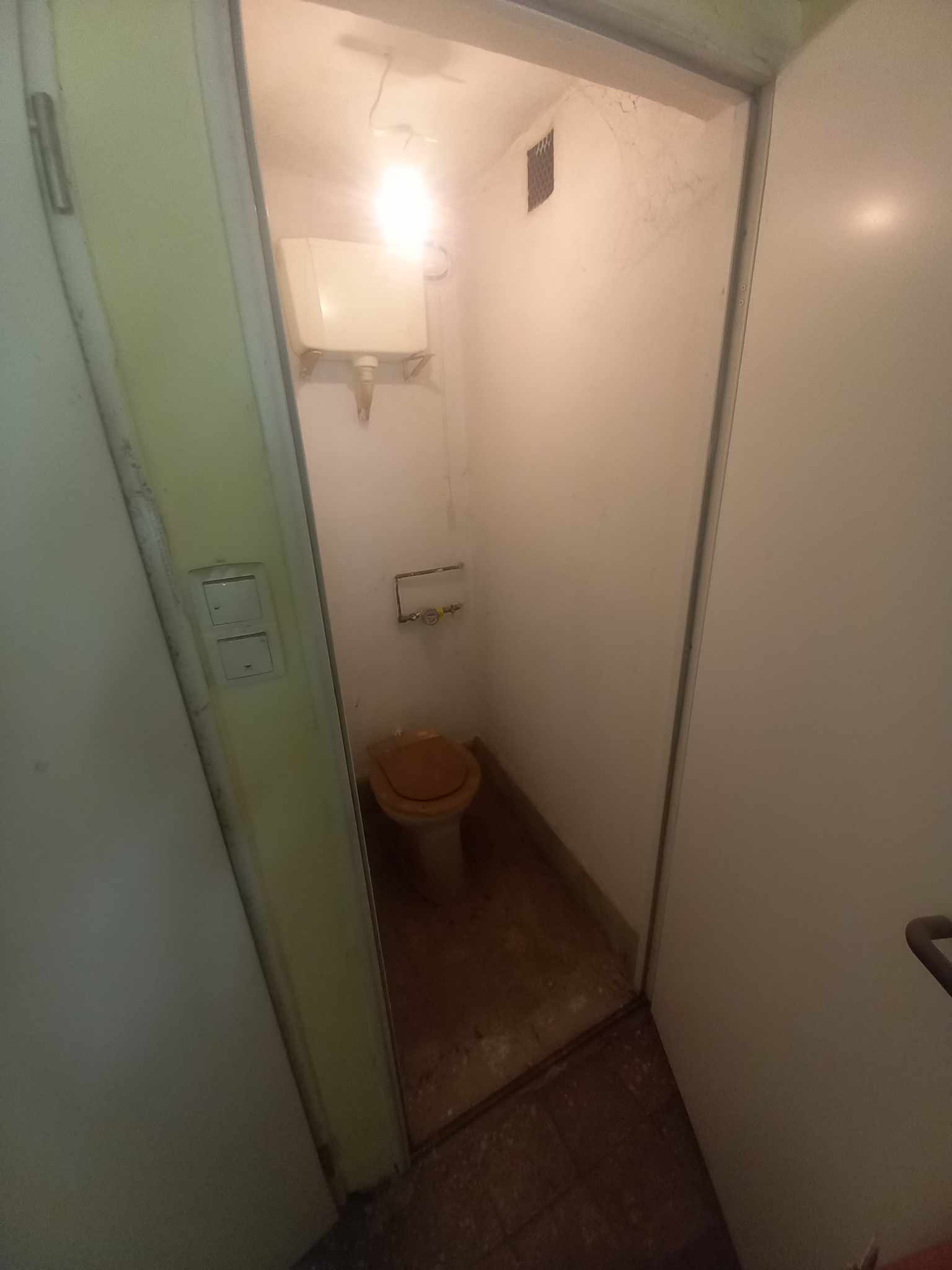 Felújítás előtti szűk WC helyiség régi tartállyal és szerelvényekkel